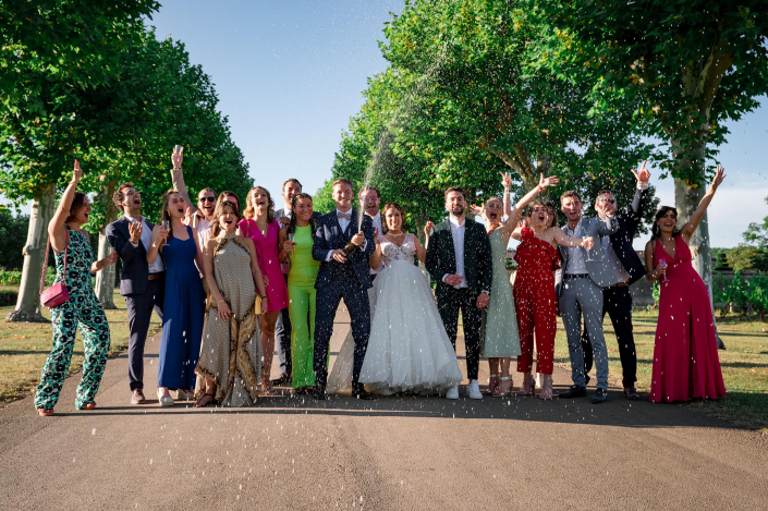 photo-mariage-chateau-pizay-groupes-champagne photo de groupe avec les mariés et leur amis qui sabrent le champagne pour faire la fête.